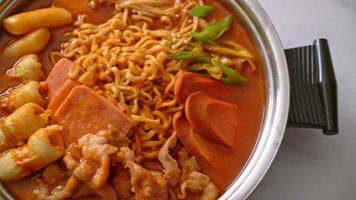 Budae Jjigae or Budaejjigae or Army stew or Army base stew. It is loaded with Kimchi, spam, sausages, ramen noodles and much more - popular Korean hot pot food style