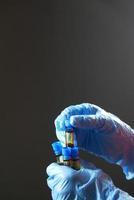 hand in blue medical gloves holding blood test tube photo