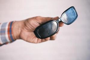 holding a Perforation glasses with holes for training vision photo