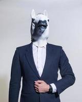 hombre con una máscara de caballo sobre un fondo claro foto