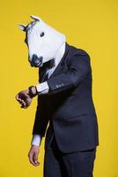 man with horse mask on yellow background photo