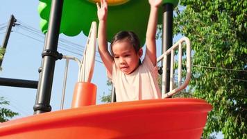 menina ativa no playground ao ar livre. menina bonitinha deslizando no controle deslizante. atividade de verão saudável para crianças.