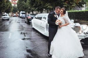 feliz pareja joven cerca del coche en la carretera foto