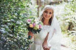 Portrait of a happy bride posing with veil photo