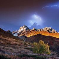 fantástico collage. hermoso relámpago sobre las cumbres nevadas foto