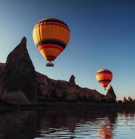 Composition of balloons over water and valleys, gorges, hills, b