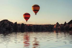 Composition of balloons over water and valleys, gorges, hills, b photo