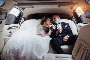 pareja joven en un coche en el día de la boda foto