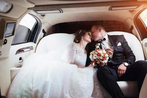 young couple in a car in wedding day photo