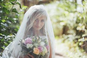 Portrait of a happy bride posing with veil photo