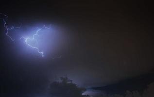 Lightning strike on the cloudy dark sky. Fantastic summer night photo