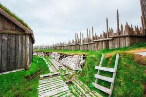 Traditional Viking village. Wooden houses near the mountain firs photo