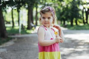 Funny child with candy lollipop, happy little girl photo