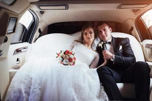 pareja joven en un coche en el día de la boda foto