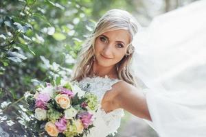Portrait of a happy bride posing with veil photo