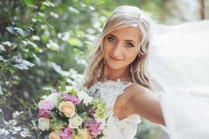 Portrait of a happy bride posing with veil photo
