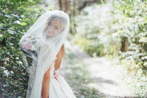 Portrait of a happy bride posing with veil photo