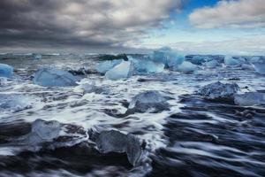 glaciar en la playa volcánica negra islandia foto