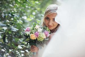 Portrait of a happy bride posing with veil photo