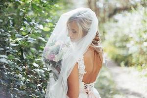 Portrait of a happy bride posing with veil photo