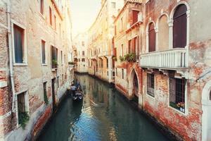 Green water canal with gondolas and colorful facades photo