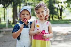 niños felices prueban dulces en un palo foto