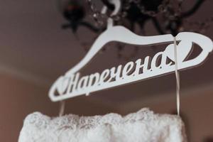 wedding dress hanging on the chandelier in the interior photo