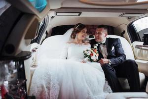 young couple in a car in wedding day photo