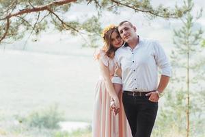 Happy young couple in a pine forest in summer photo