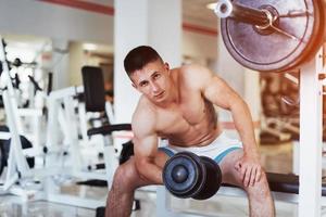 Portrait of a beautiful athletic guy muscles with weights photo