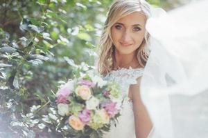 Portrait of a happy bride posing with veil photo