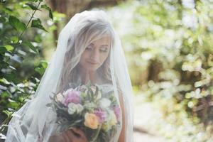 Portrait of a happy bride posing with veil photo