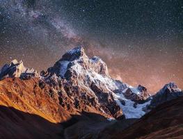 Fantastic starry sky. Autumn landscape and snow-capped peaks. Ma photo