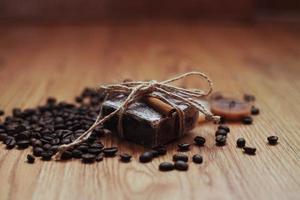 Organic soap with coffee beans and spices, on wooden background.