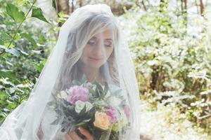 Portrait of a happy bride posing with veil photo