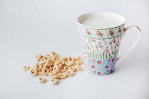 Corn flakes and milk in cup on a white background. photo