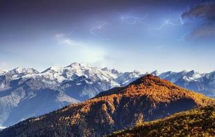 Fantastic collage. Beautiful lightning over the snow-capped moun photo