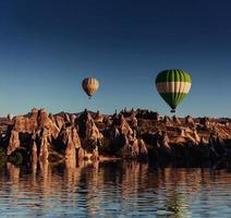 Composition of balloons over water and valleys, gorges, hills, b