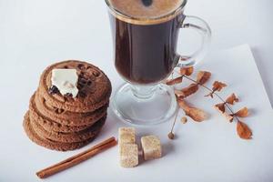 Glass cup of hot coffee with cookies and chocolate photo