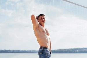 muscular male model with perfect body posing in blue jeans photo