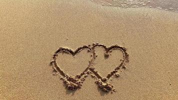 zachte golven op het strand met twee hartjes video