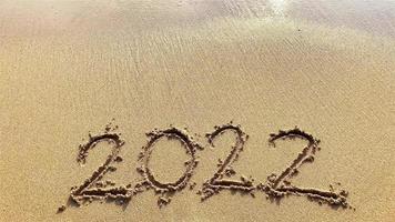 morbide onde sulla spiaggia con il numero 2022 video