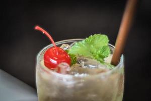 Fresh summer drink mocktail beverage pour in glass cherry and mint leaf decoration on top. photo