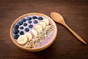 tazón de yogur o batido de yogur con bayas azules, plátano y granola foto