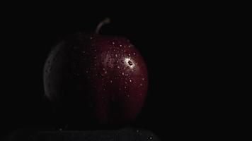 rött äpple i daggdroppar och bländande på det video