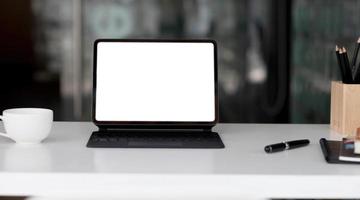 Side view of contemporary workplace with laptop computer, notebook, coffee cup and stationery on wooden table. photo