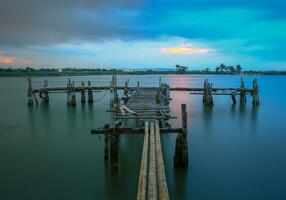 un muelle al atardecer en la playa foto