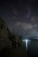 impresionantes estrellas se elevan sobre la presa en la noche foto