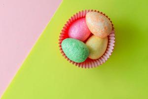 Colorful Easter decorative eggs on yellow and pink colored paper photo