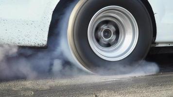 Drag Racing Car quema el caucho de sus neumáticos en preparación para la carrera